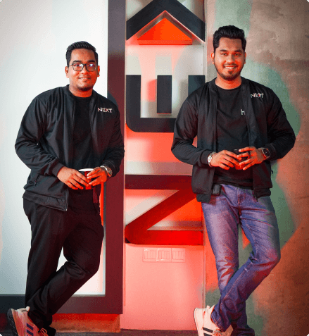 FundedNext Leaders Leaning on Wall Holding Coffee Cups